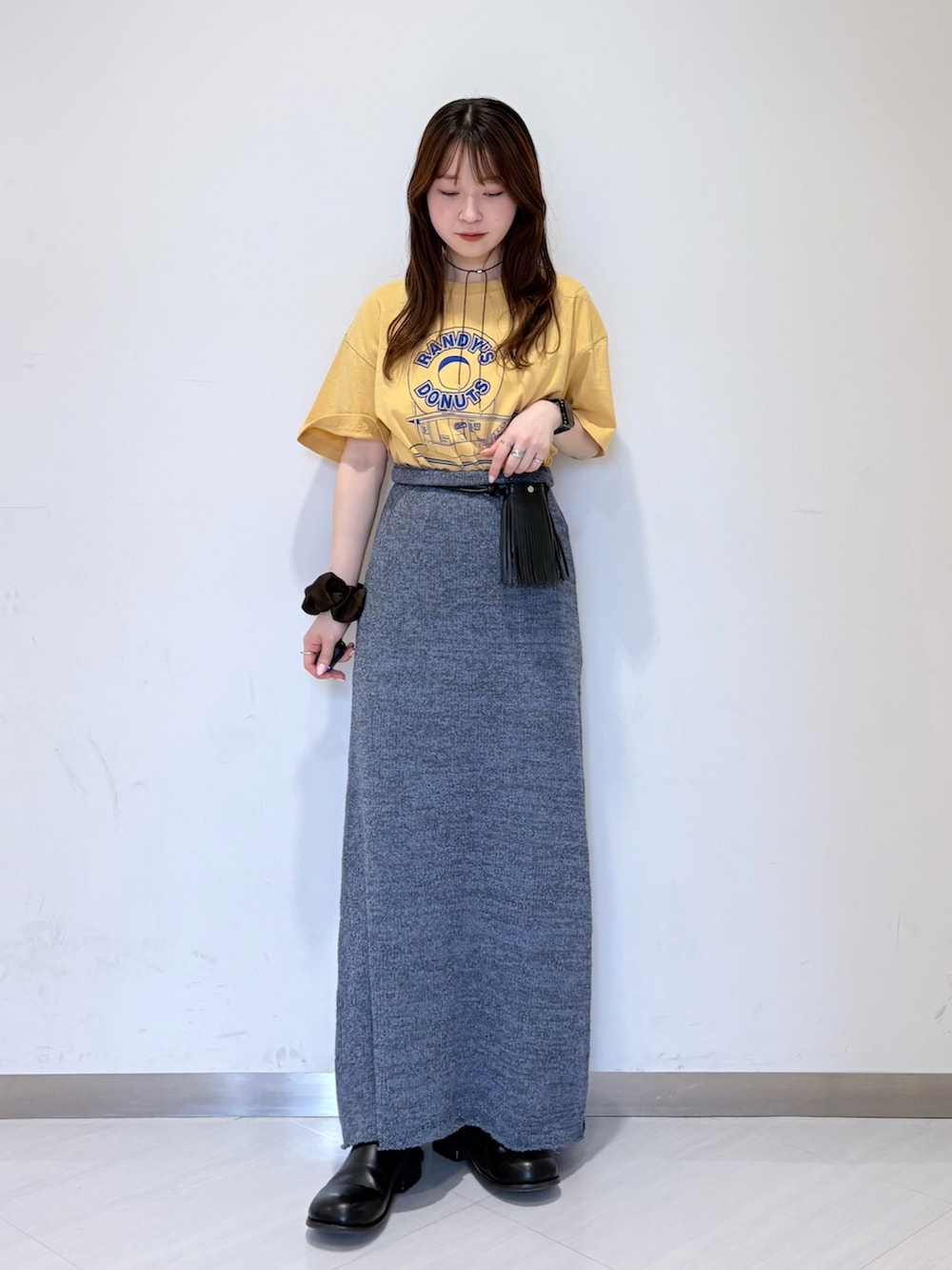 ブルー系のスカート、ブラック系のその他シューズ、イエロー系のTシャツ/カットソーを着用したレディースの春コーディネートの2枚目の写真