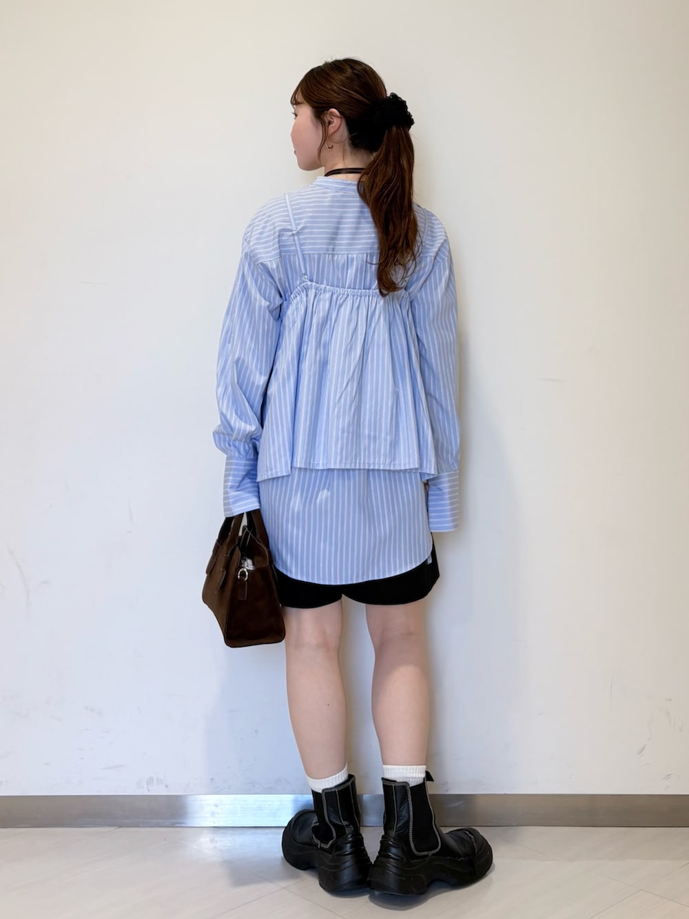 ブルー系のシャツ/ブラウス、ブラック系のその他パンツ、ブラウン系のショルダーバッグを着用したレディースの春コーディネートの4枚目の写真