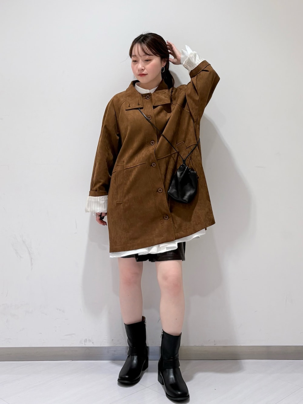 ブラック系のブーツ、ブラック系のショルダーバッグ、ホワイト系のシャツ/ブラウスを着用したレディースの秋コーディネートの2枚目の写真