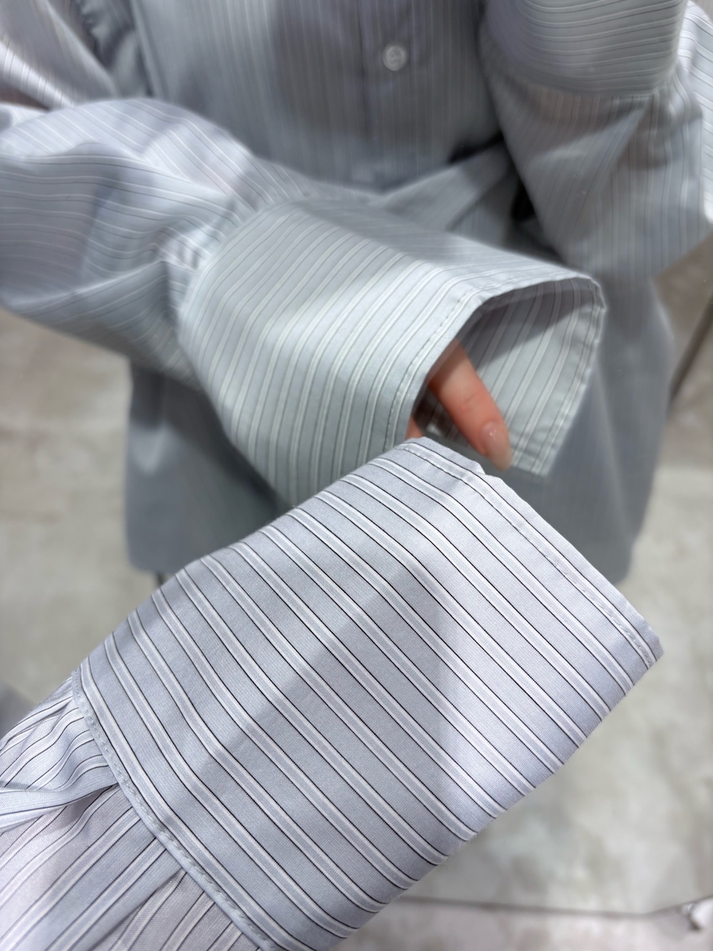 グレー系のシャツ/ブラウス、ホワイト系のパンプス、ブラウン系のボストンバッグを着用したレディースの冬コーディネートの5枚目の写真