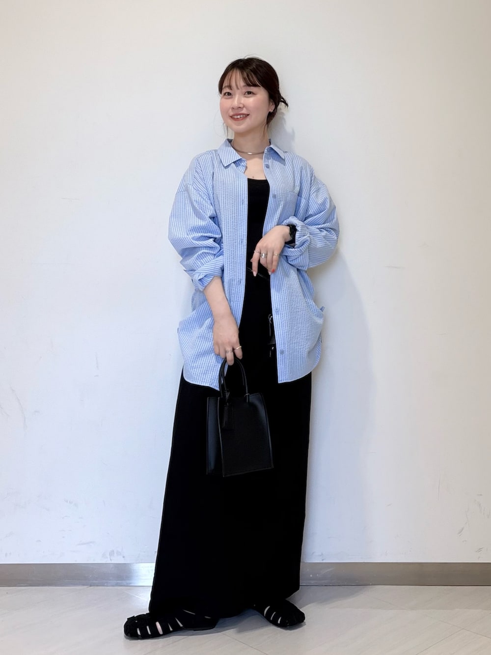 ブルー系のシャツ/ブラウス、ブラック系のショルダーバッグ、ブラック系のハンドバッグを着用したレディースの春コーディネートの5枚目の写真