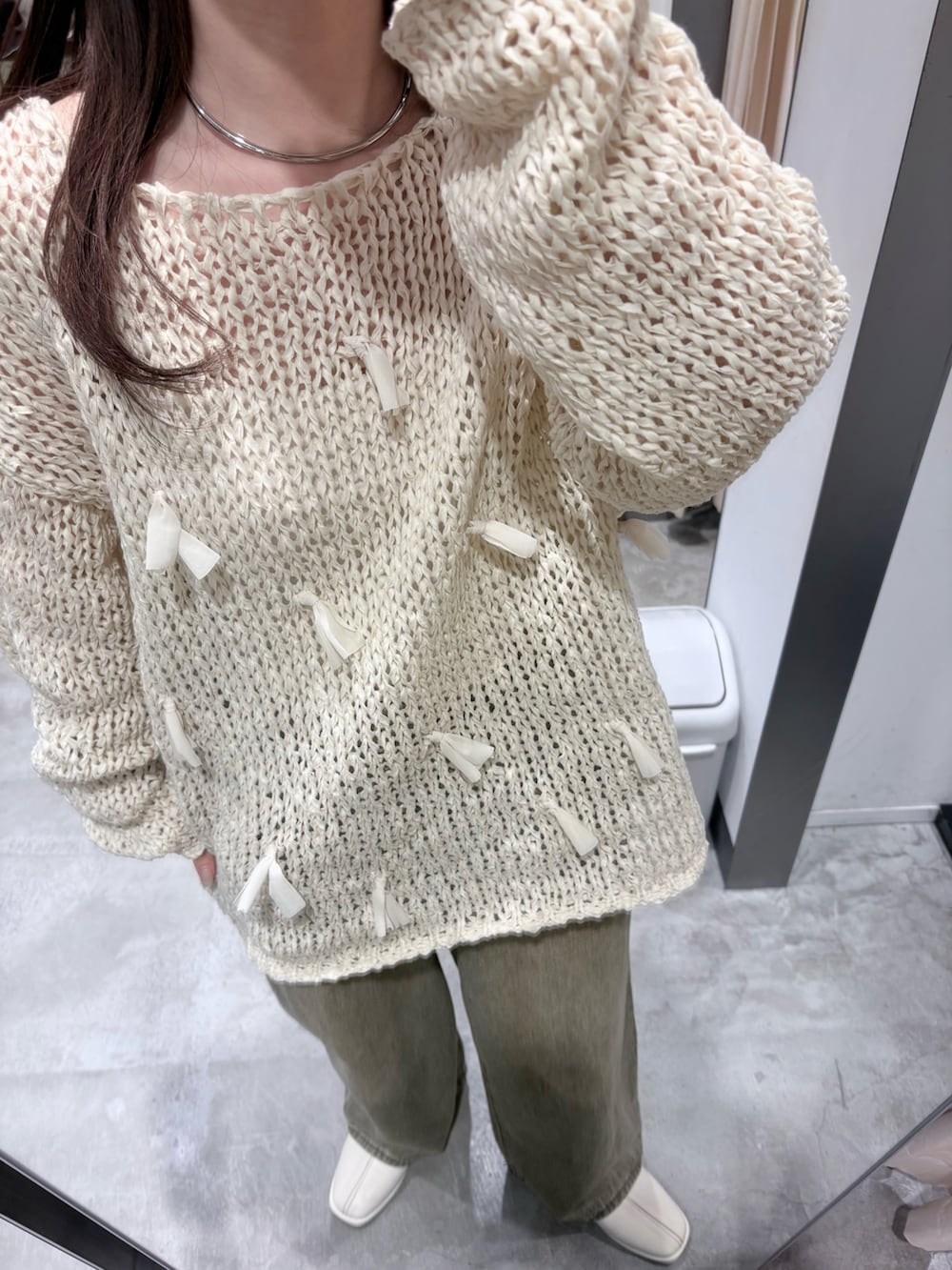 ホワイト系のパンプス、グリーン系のデニムパンツ、ブラウン系のボストンバッグを着用したレディースの冬コーディネートの5枚目の写真