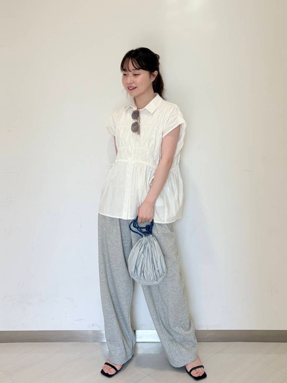 グレー系のその他パンツ、ブルー系のサンダル、ホワイト系のシャツ/ブラウスを着用したレディースの夏コーディネートの3枚目の写真