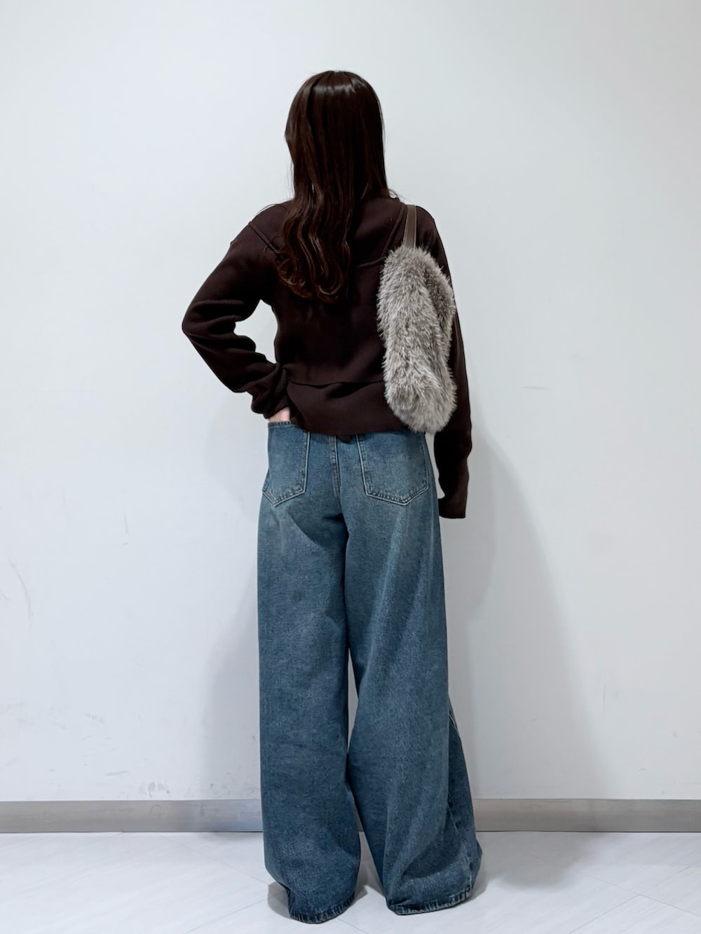 ブラウン系のニット/セーター、ブルー系のデニムパンツ、ブラウン系のその他シューズを着用したレディースの秋コーディネートの2枚目の写真