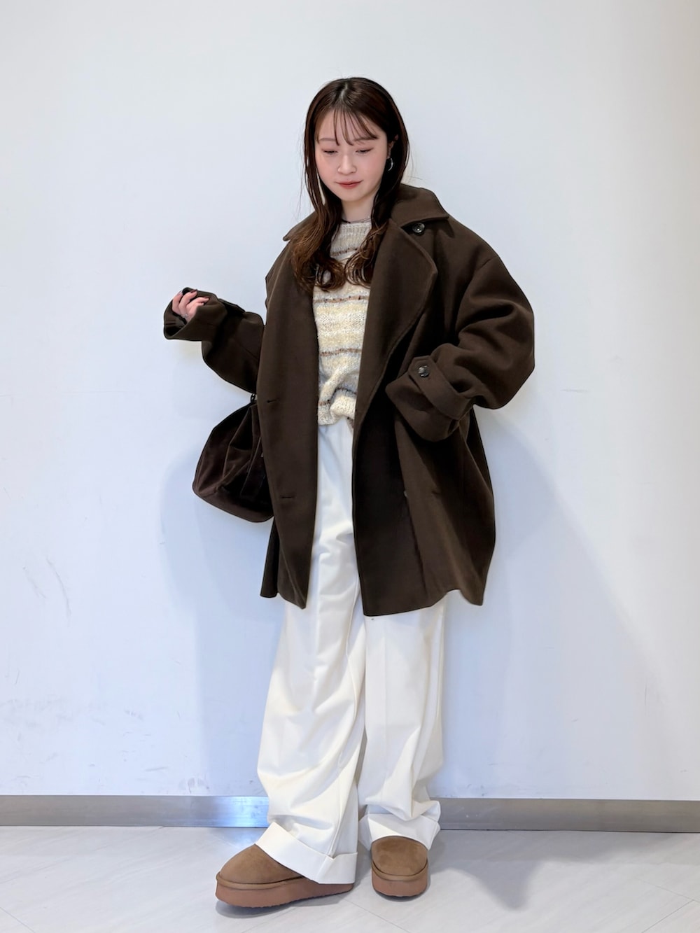 ブラウン系のその他アウター、ホワイト系のニット/セーター、ブラウン系のボストンバッグを着用したレディースの冬コーディネートの2枚目の写真