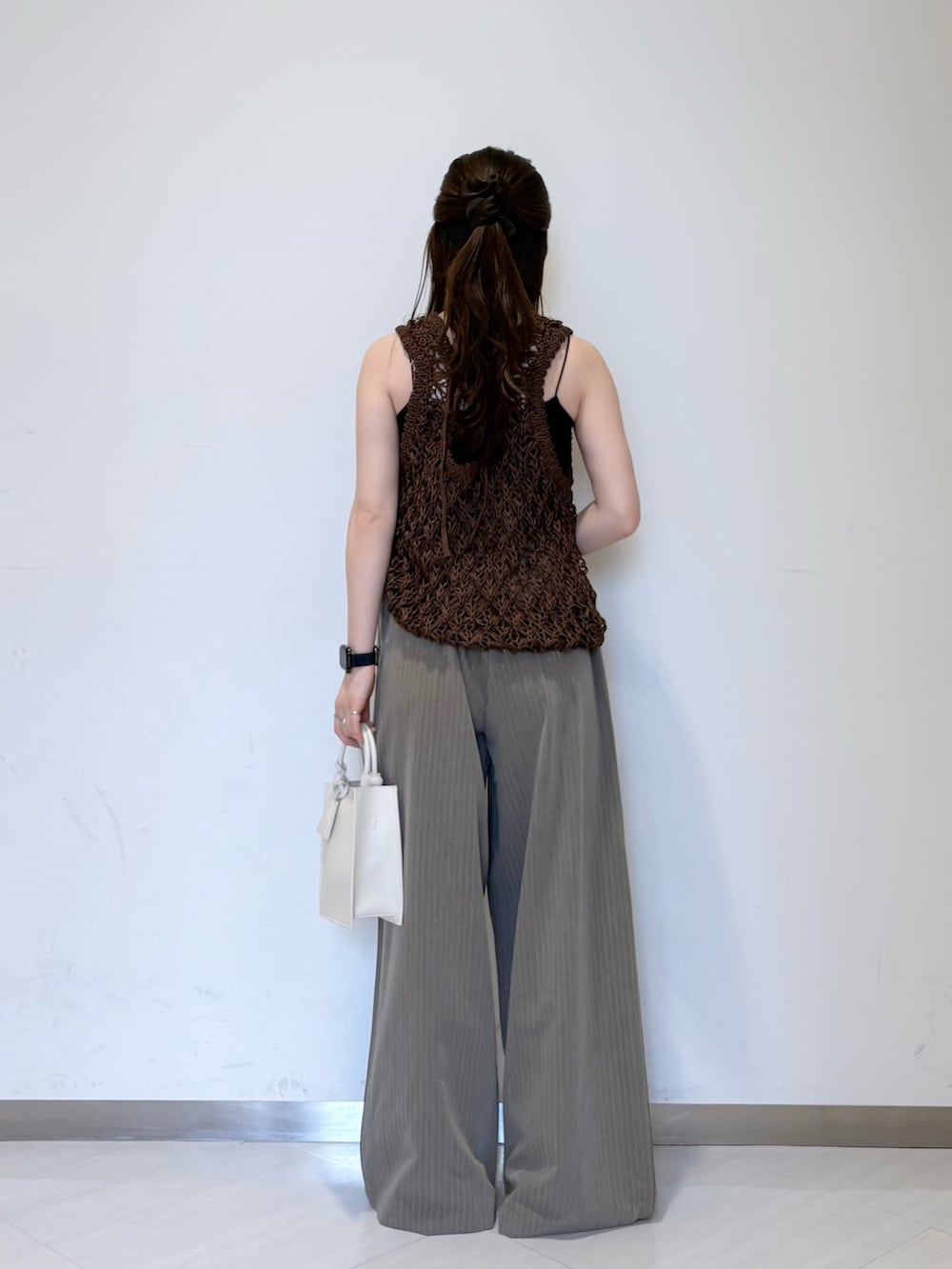 ホワイト系のニット/セーター、ブラウン系のその他パンツ、ブラック系のキャミソールを着用したレディースの春コーディネートの4枚目の写真