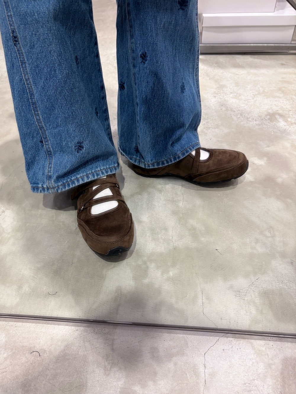 ブルー系のワンピース、ブラウン系のボストンバッグ、ブルー系のデニムパンツを着用したレディースの冬コーディネートの4枚目の写真