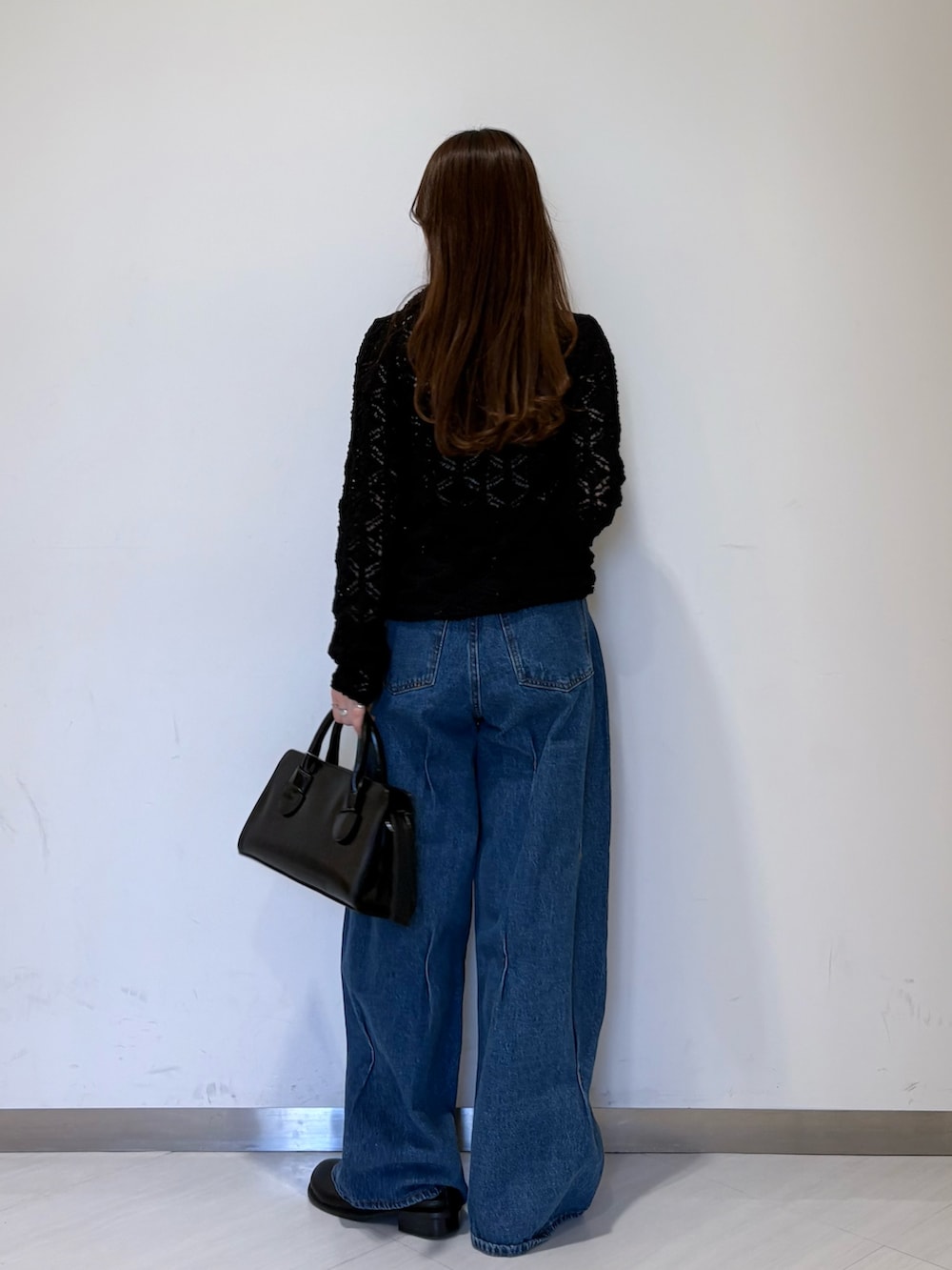 ブルー系のデニムパンツ、ブラック系のその他シューズ、ブラック系のボストンバッグを着用したレディースの冬コーディネートの3枚目の写真