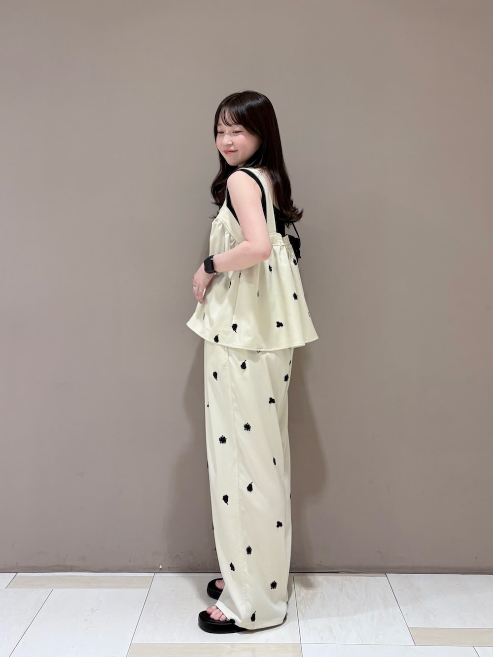 ブラック系のタンクトップ、ホワイト系のシャツ/ブラウス、ブラック系のサンダルを着用したレディースの夏コーディネートの2枚目の写真