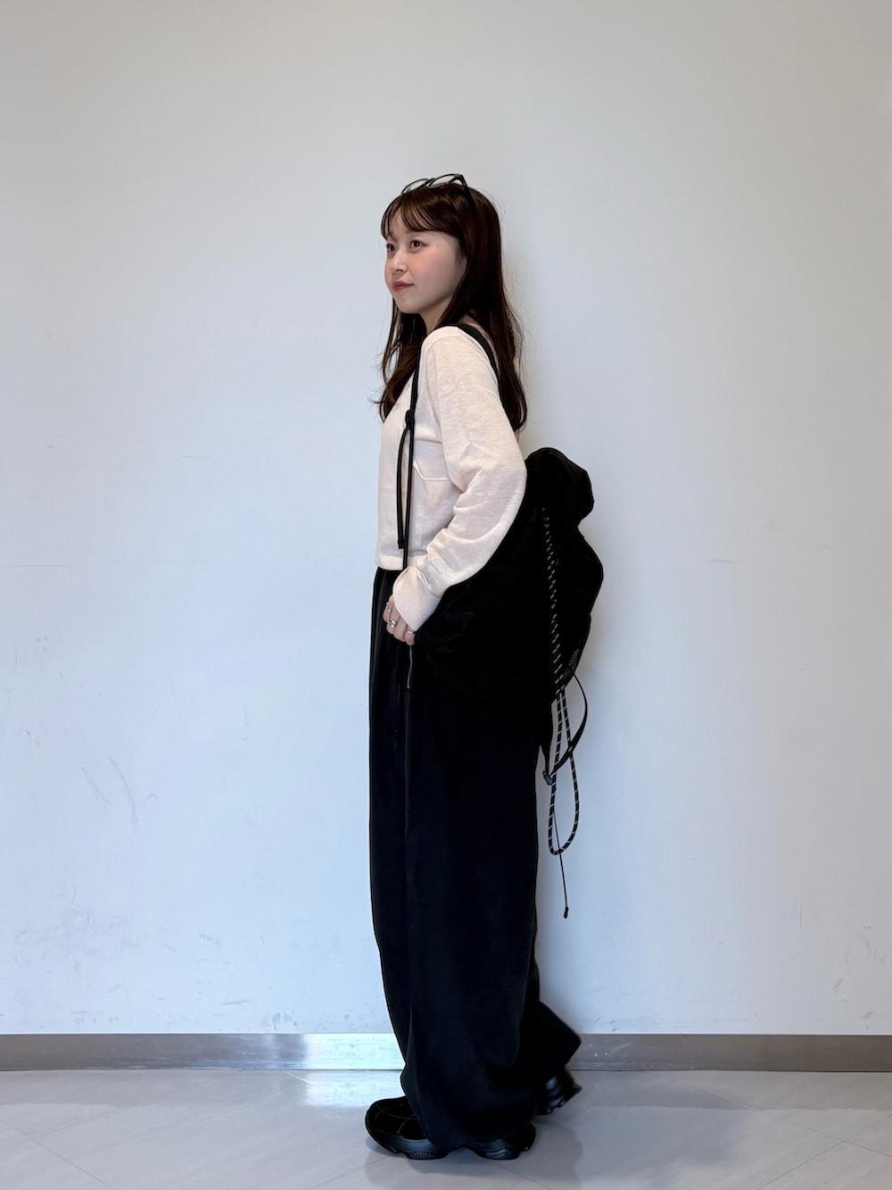 ピンク系のカーディガン/ボレロ、グレー系のその他パンツ、ブラック系のバックパック/リュックを着用したレディースの夏コーディネートの2枚目の写真