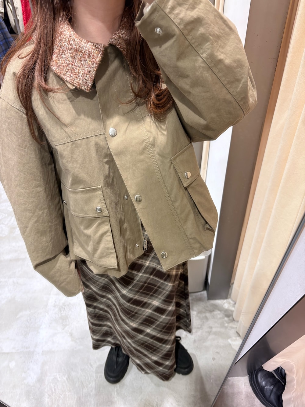 グリーン系のブルゾン、ブラウン系のスカート、ブラック系のスニーカーを着用したレディースの冬コーディネートの4枚目の写真