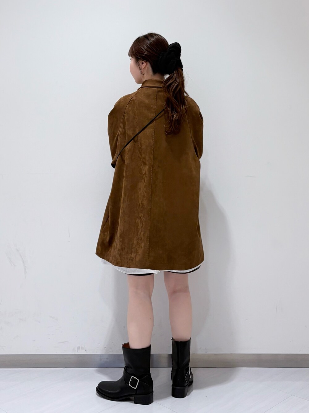 ブラック系のブーツ、ブラック系のショルダーバッグ、ホワイト系のシャツ/ブラウスを着用したレディースの秋コーディネートの3枚目の写真