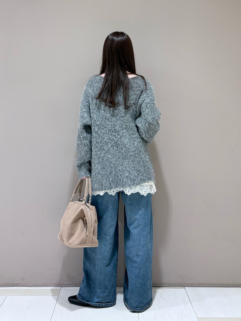 グレー系のニット/セーター、ブラック系のパンプス、ホワイト系のキャミソールを着用したレディースの冬コーディネートの3枚目の写真