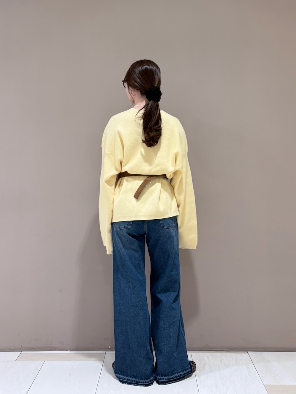 ブルー系のデニムパンツ、その他のバレエシューズ、イエロー系のボディバッグ/ウエストポーチを着用したレディースの秋コーディネートの3枚目の写真