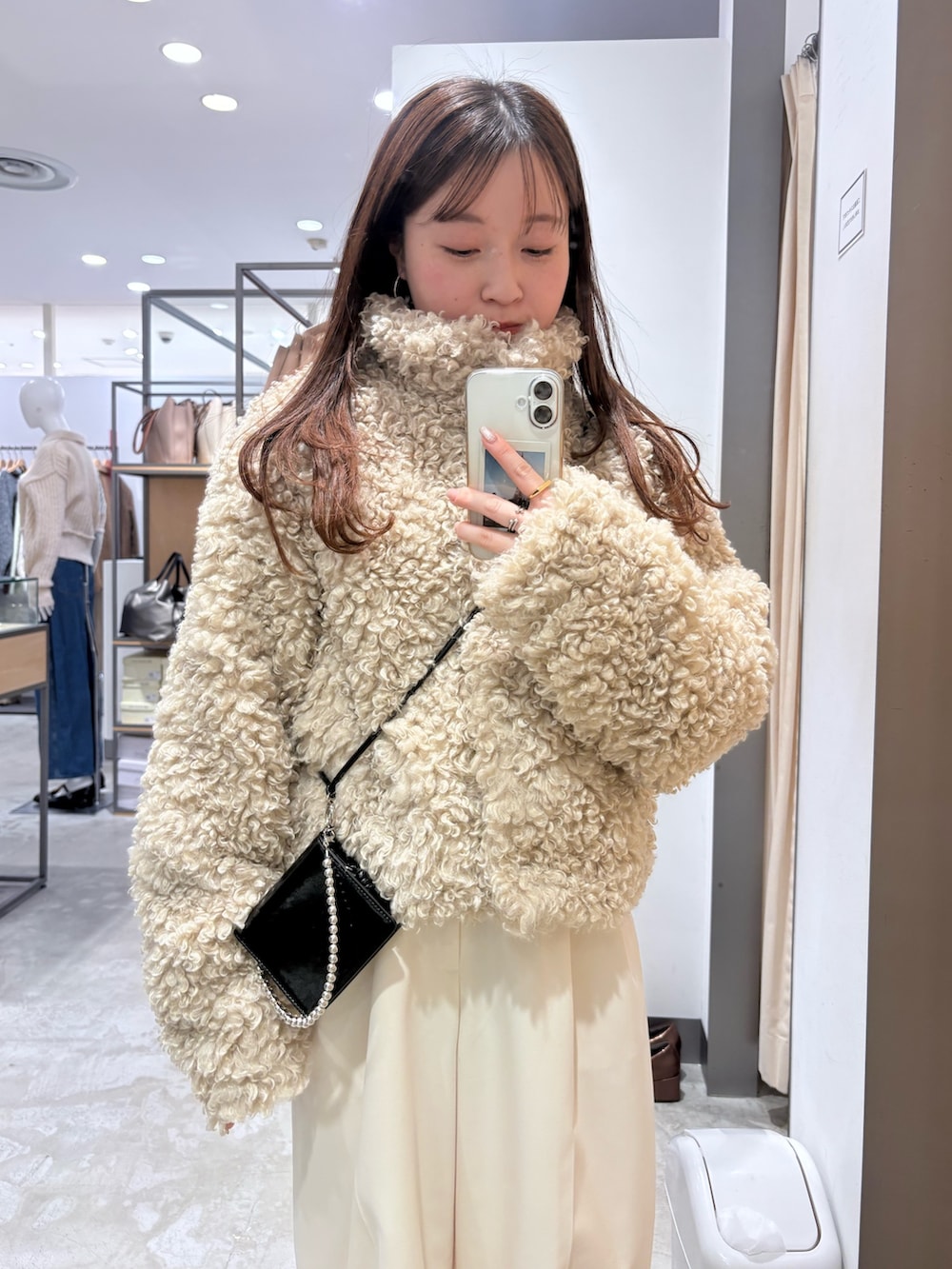 ホワイト系のその他アウター、ホワイト系のその他パンツ、ブラック系のスニーカーを着用したレディースの冬コーディネートの4枚目の写真