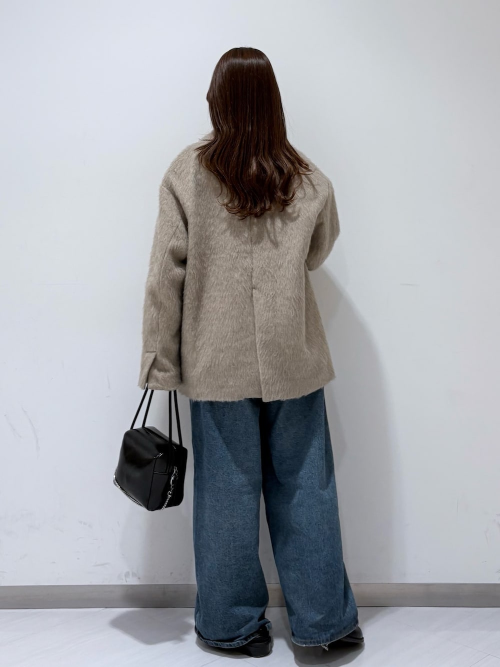ブラウン系のその他アウター、グレー系のニット/セーター、ブルー系のデニムパンツを着用したレディースの冬コーディネートの3枚目の写真