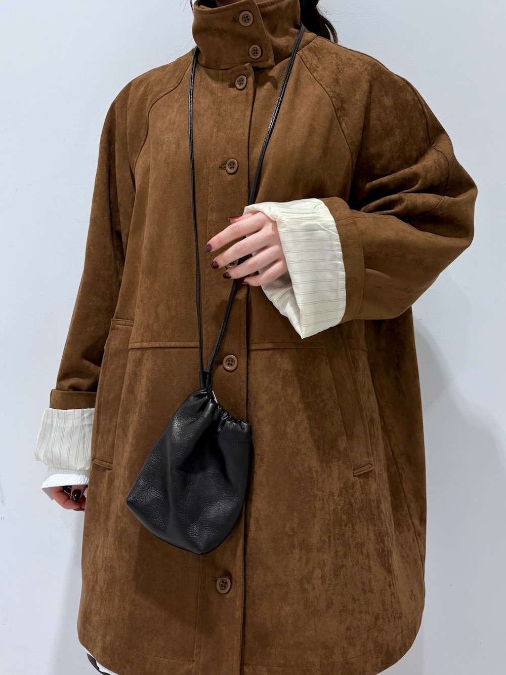 ブラック系のブーツ、ブラック系のショルダーバッグ、ホワイト系のシャツ/ブラウスを着用したレディースの秋コーディネートの5枚目の写真