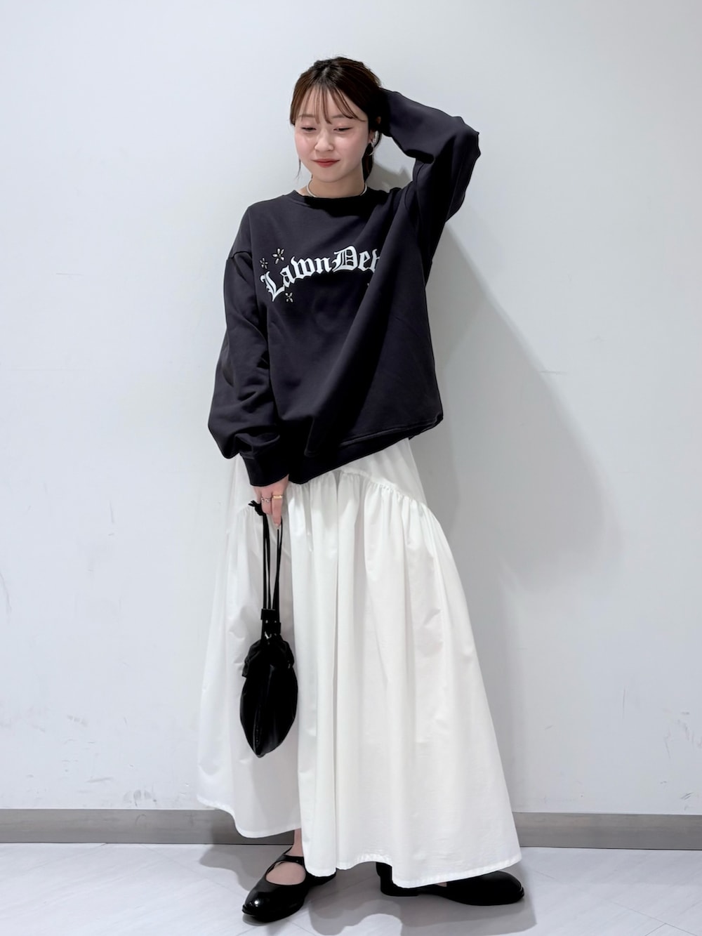 グレー系のスウェット、ブラック系のローファー、ホワイト系のスカートを着用したレディースの春コーディネートの5枚目の写真