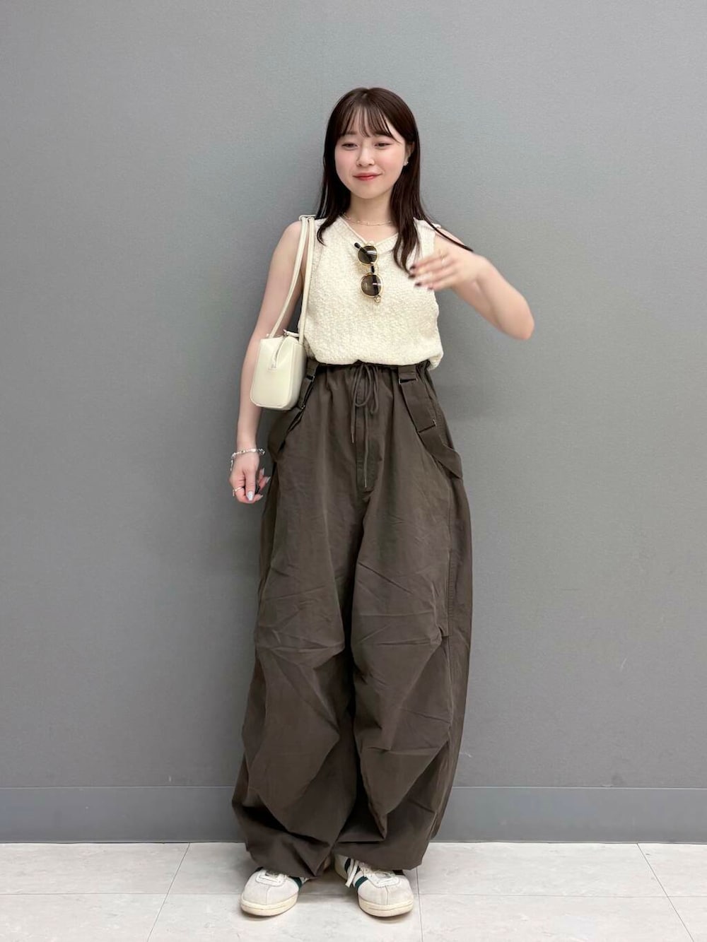 ホワイト系のショルダーバッグ、ホワイト系のニット/セーター、ブラウン系のその他パンツを着用したレディースの夏コーディネートの2枚目の写真