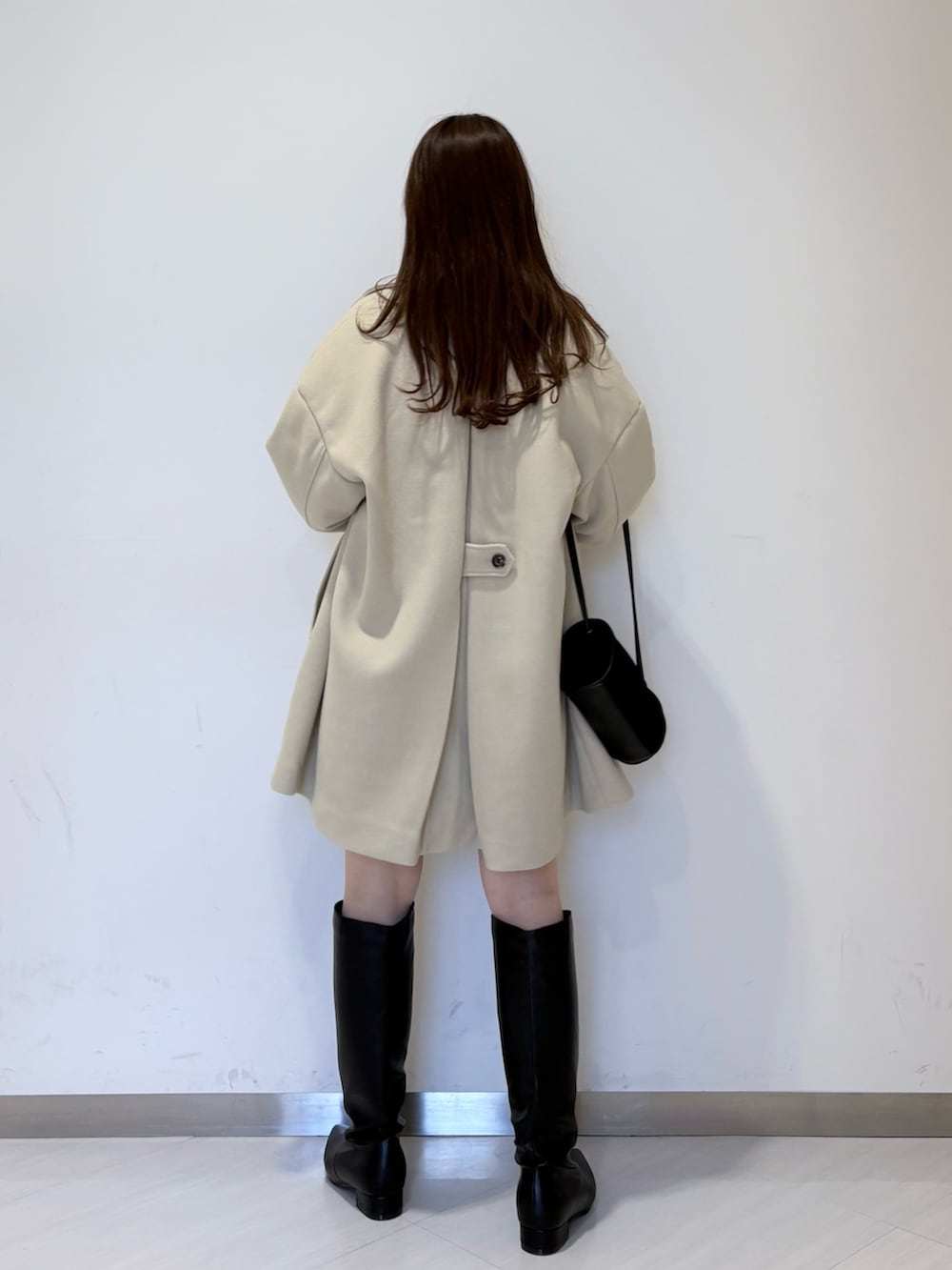 ベージュ系のその他アウター、グリーン系のニット/セーター、ブラウン系のその他パンツを着用したレディースの冬コーディネートの2枚目の写真