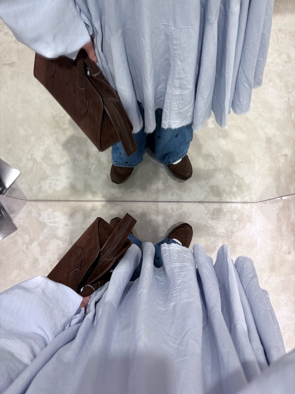 ブルー系のワンピース、ブラウン系のボストンバッグ、ブルー系のデニムパンツを着用したレディースの冬コーディネートの3枚目の写真