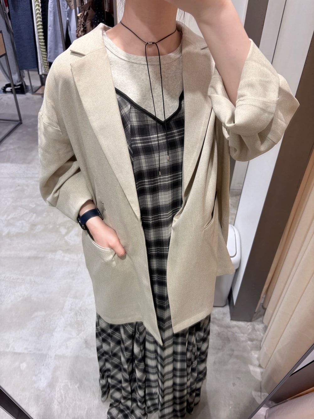 ベージュ系のタンクトップ、ブラック系のワンピース、ブラック系のハンドバッグを着用したレディースの春コーディネートの6枚目の写真