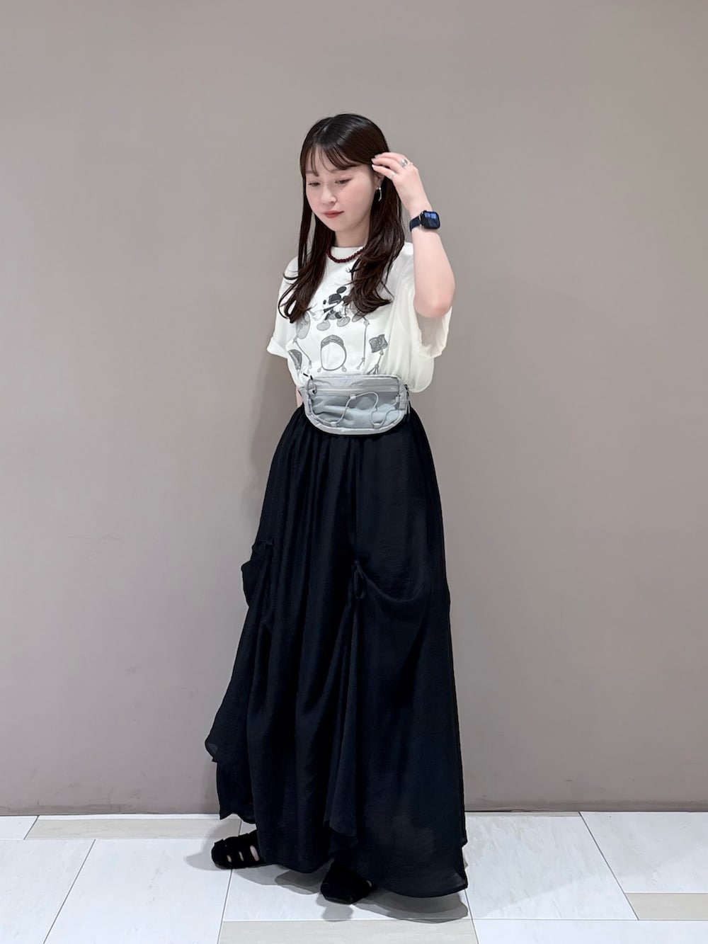 ホワイト系のTシャツ/カットソー、ブラック系のスカート、グレー系のボディバッグ/ウエストポーチを着用したレディースの春コーディネートの4枚目の写真
