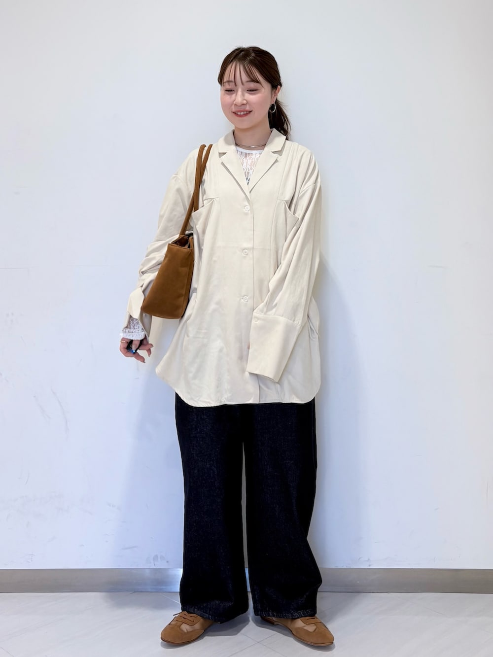 ホワイト系のシャツ/ブラウス、ブルー系のデニムパンツ、イエロー系のボストンバッグを着用したレディースの冬コーディネートの2枚目の写真