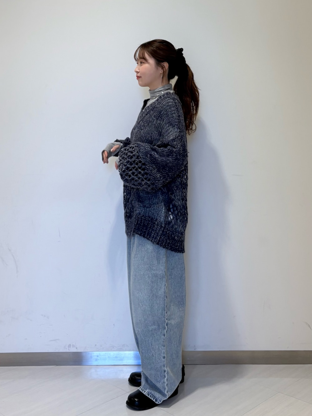 ブルー系のニット/セーター、グレー系のTシャツ/カットソー、ブルー系のデニムパンツを着用したレディースの秋コーディネートの2枚目の写真
