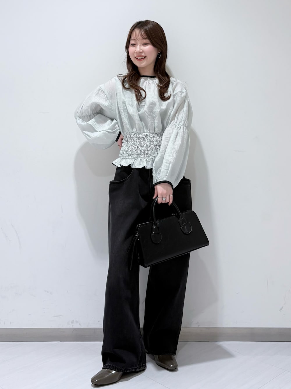 ブルー系のシャツ/ブラウス、グリーン系のパンプス、ブラック系のデニムパンツを着用したレディースの春コーディネートの4枚目の写真