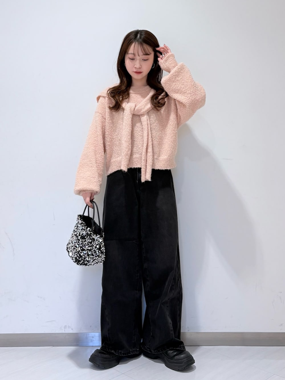 ピンク系のニット/セーター、ブラック系のデニムパンツを着用したレディースの冬コーディネートの2枚目の写真