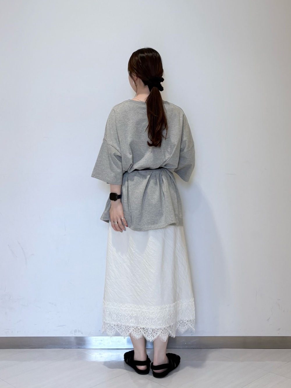 グレー系のTシャツ/カットソー、ホワイト系のスカート、ブラック系のサンダルを着用したレディースの夏コーディネートの3枚目の写真