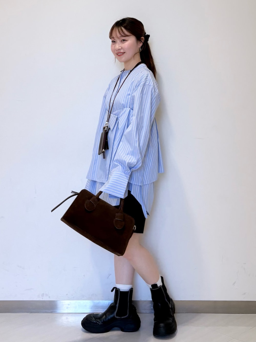 ブルー系のシャツ/ブラウス、ブラック系のその他パンツ、ブラウン系のショルダーバッグを着用したレディースの春コーディネートの2枚目の写真