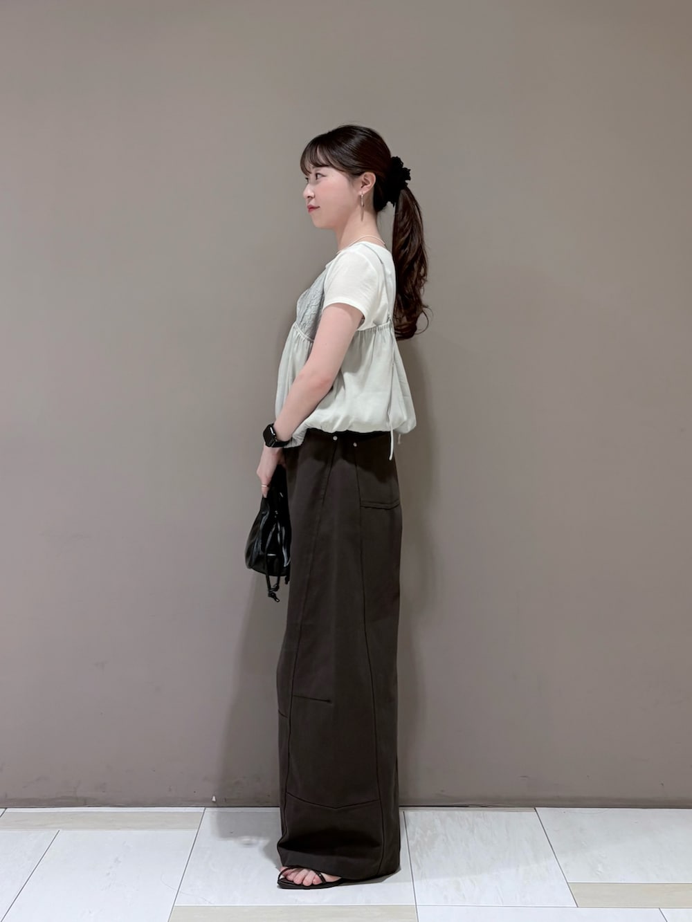 ホワイト系のTシャツ/カットソー、グレー系のその他トップス、ブラック系のハンドバッグを着用したレディースの夏コーディネートの2枚目の写真