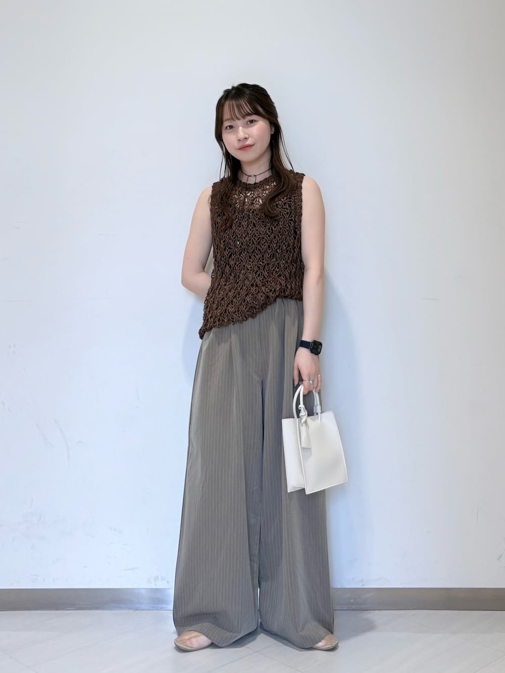 ホワイト系のニット/セーター、ブラウン系のその他パンツ、ブラック系のキャミソールを着用したレディースの春コーディネートの5枚目の写真
