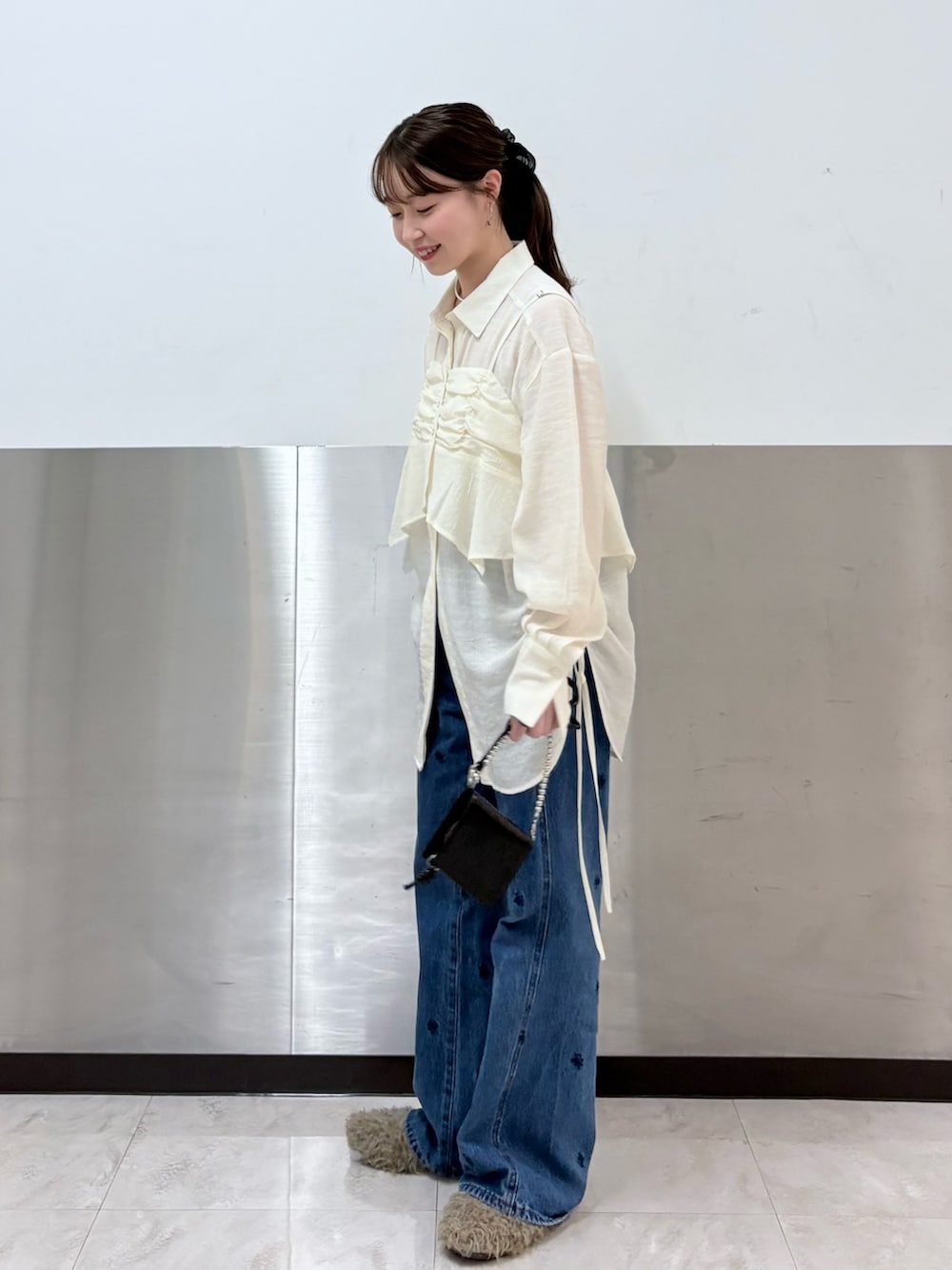 ブラウン系のその他アウター、ホワイト系のシャツ/ブラウス、ブルー系のデニムパンツを着用したレディースの秋コーディネートの4枚目の写真