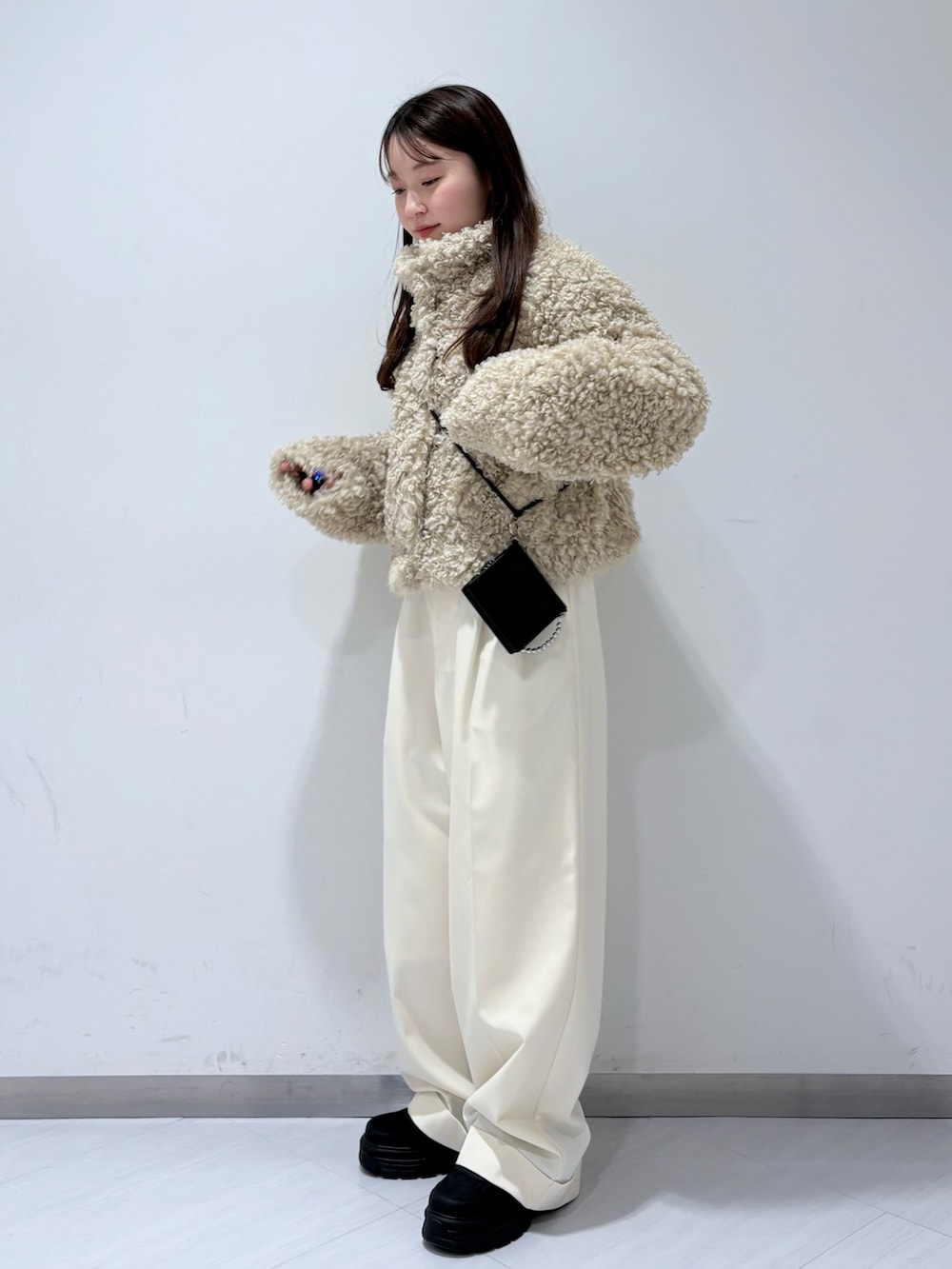 ホワイト系のその他アウター、ホワイト系のその他パンツ、ブラック系のスニーカーを着用したレディースの冬コーディネートの2枚目の写真