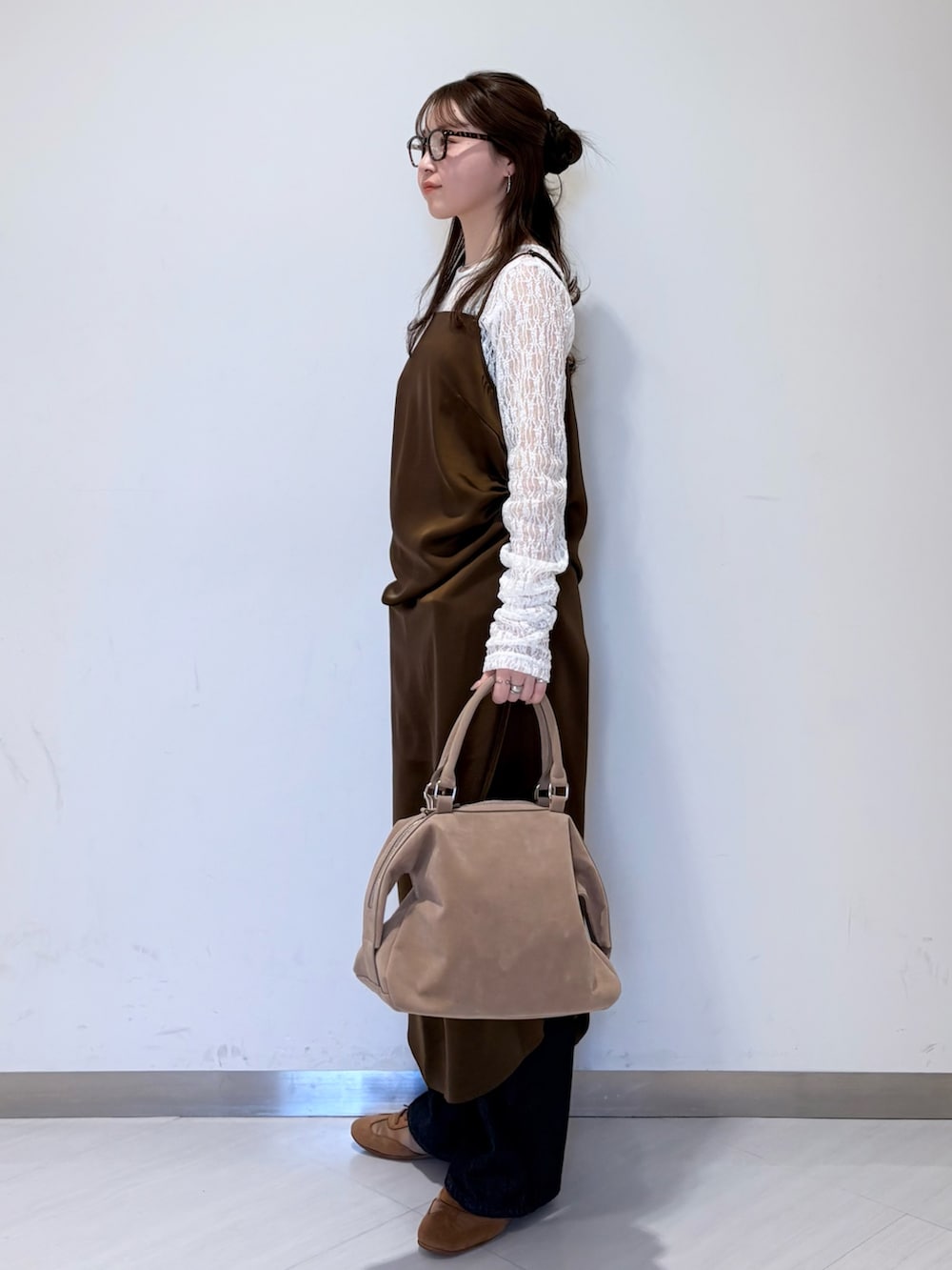 ホワイト系のTシャツ/カットソー、ブラウン系のワンピース、ブルー系のデニムパンツを着用したレディースの冬コーディネートの2枚目の写真