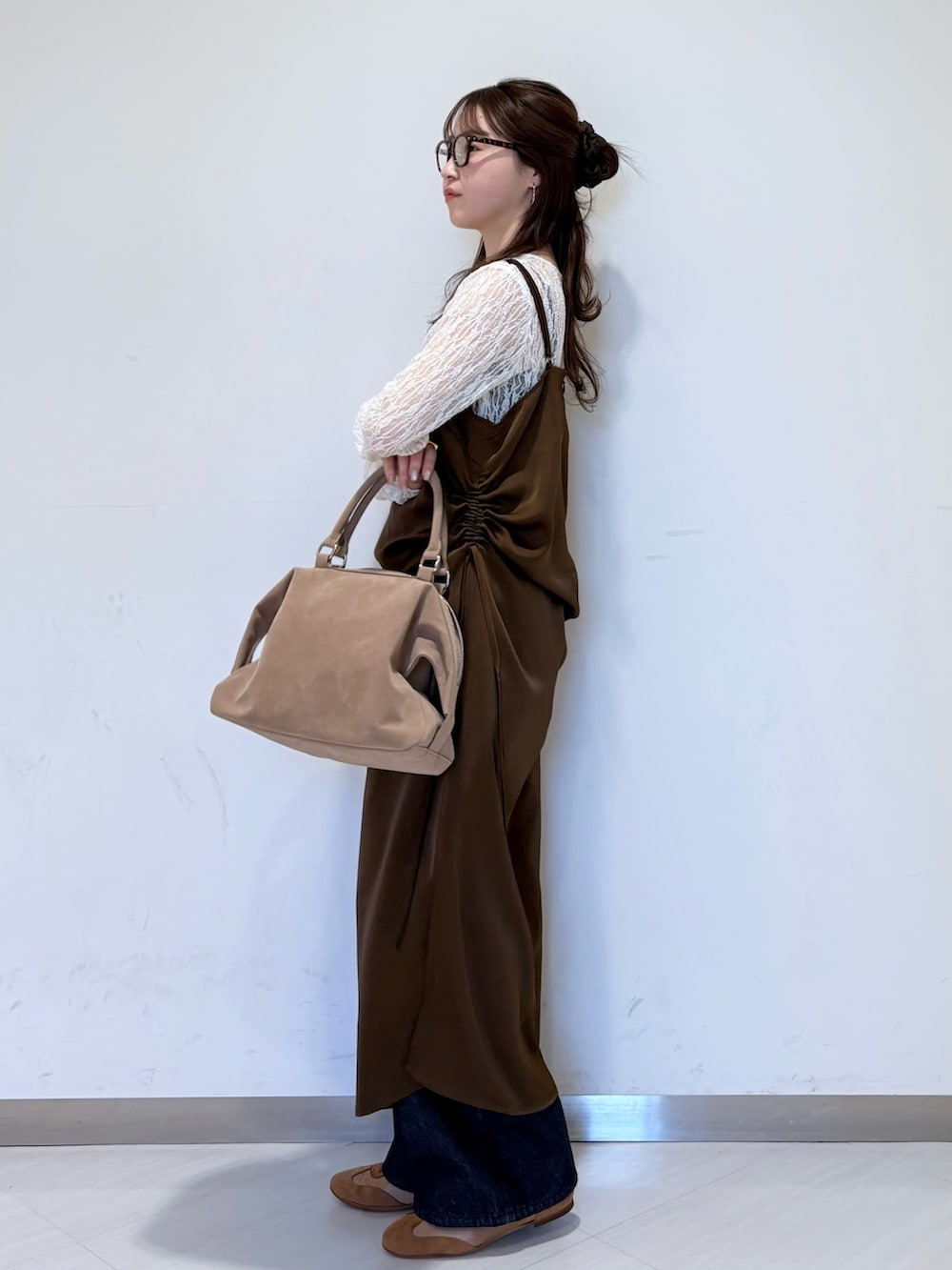 ホワイト系のTシャツ/カットソー、ブラウン系のワンピース、ブルー系のデニムパンツを着用したレディースの冬コーディネートの4枚目の写真