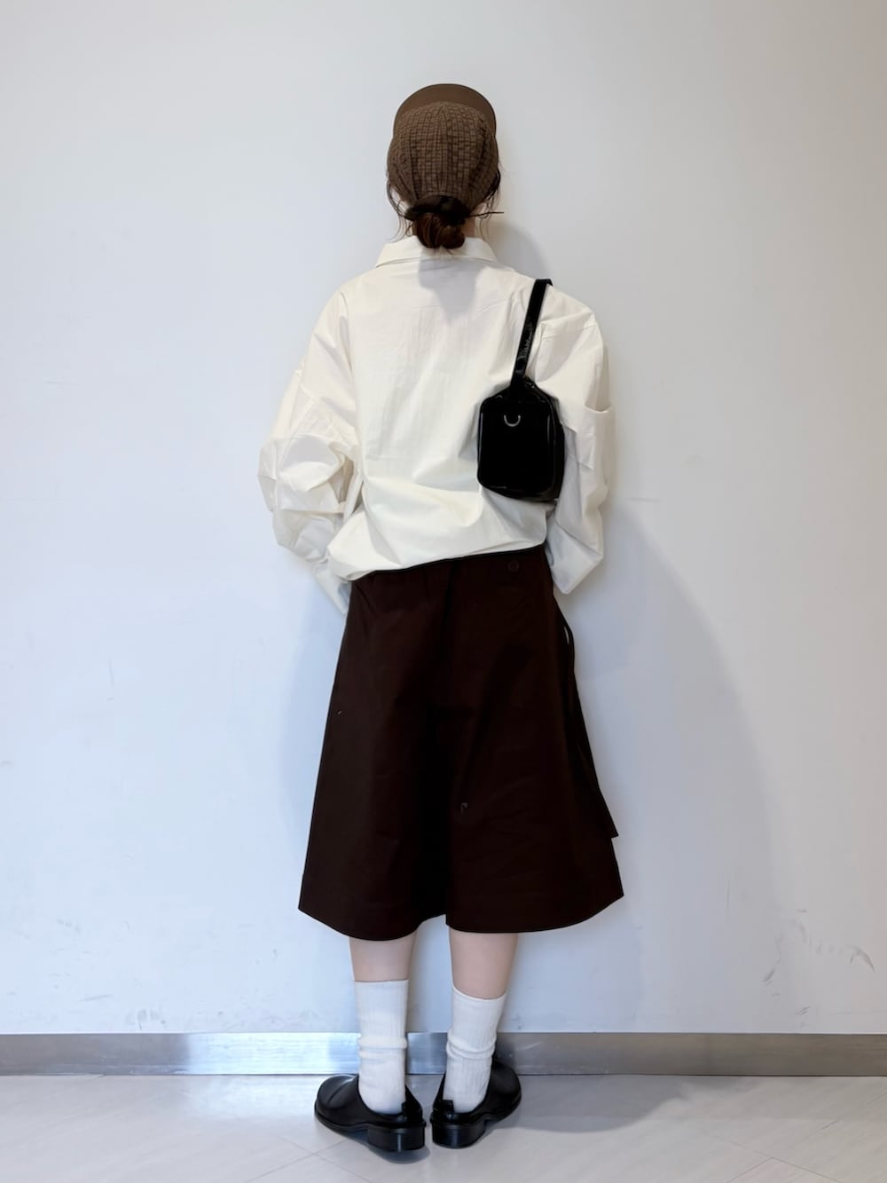 ブラック系のその他シューズ、ブラウン系のその他パンツ、ホワイト系のその他アウターを着用したレディースの春コーディネートの2枚目の写真