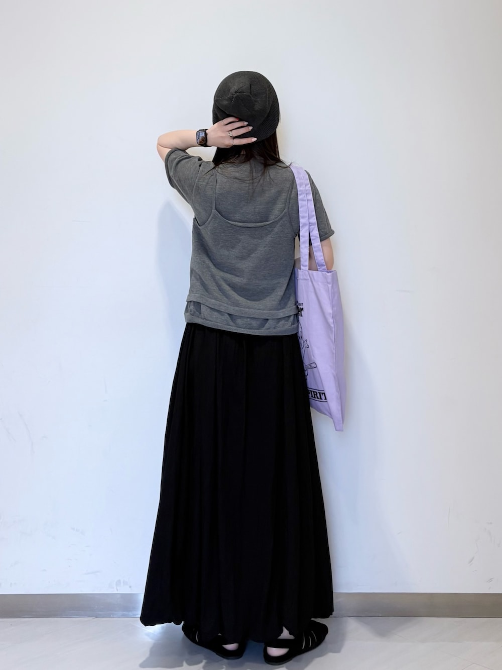 ブラック系のスカート、ブラック系のサンダル、グレー系のカーディガン/ボレロを着用したレディースの春コーディネートの2枚目の写真