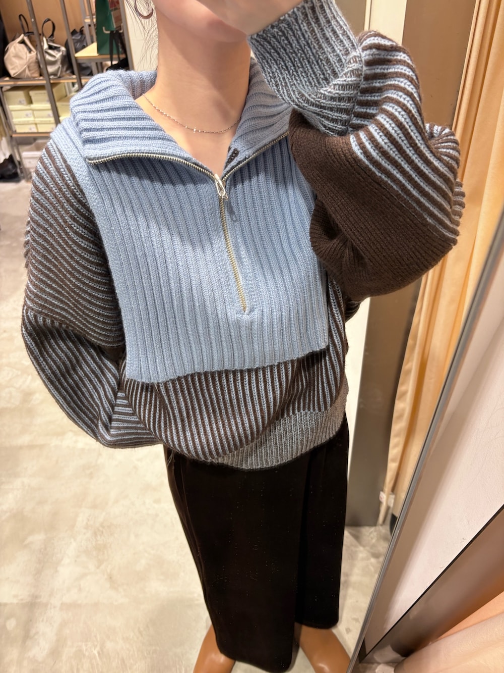 ブルー系のニット/セーター、ブラウン系のスカート、ブラウン系のブーツを着用したレディースの秋コーディネートの5枚目の写真