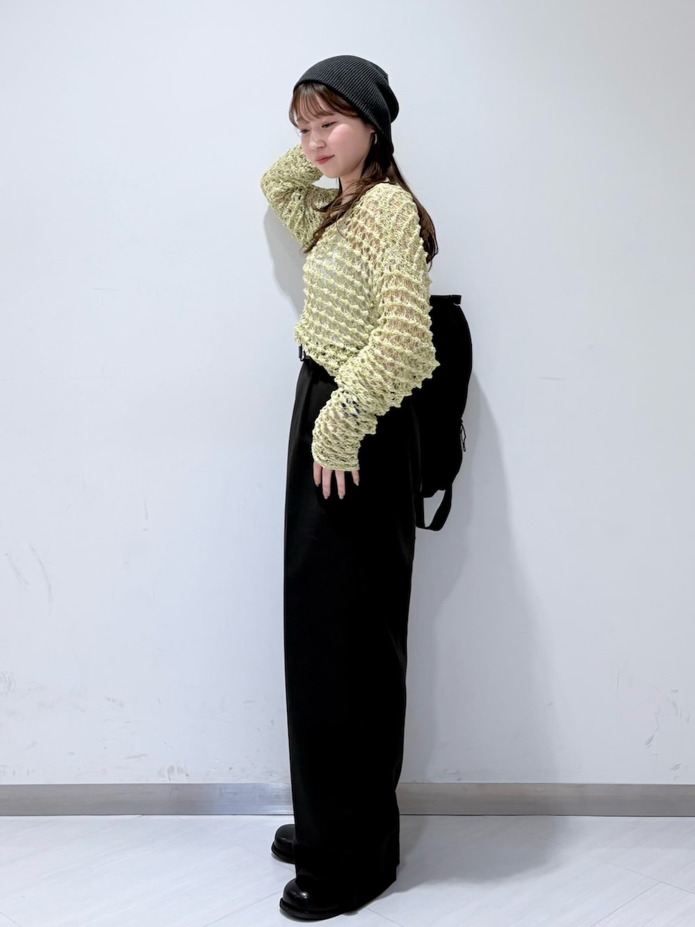 ブラック系のサンダル、グレー系のその他パンツ、グリーン系のニット/セーターを着用したレディースの春コーディネートの2枚目の写真