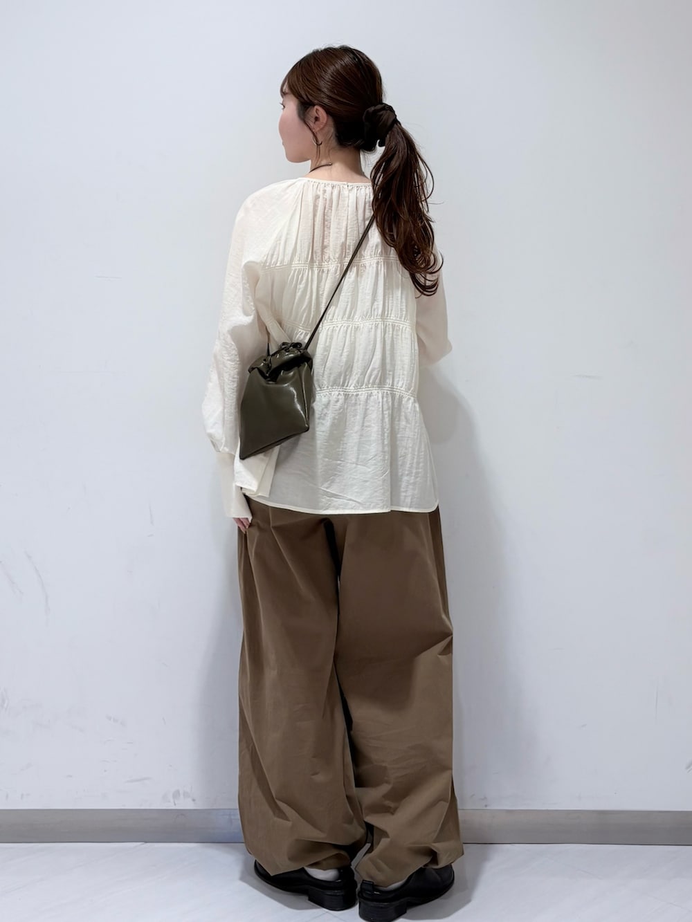 ホワイト系のシャツ/ブラウス、グリーン系のショルダーバッグ、グリーン系のその他パンツを着用したレディースの春コーディネートの2枚目の写真