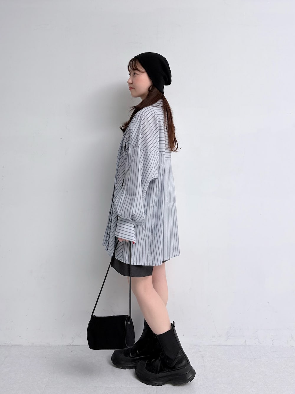 ブルー系のチュニック、グレー系のその他パンツ、ブラック系のショルダーバッグを着用したレディースの夏コーディネートの2枚目の写真