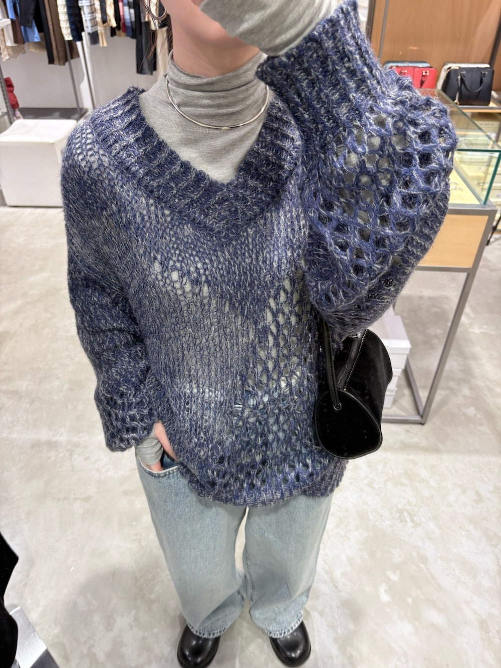 ブルー系のニット/セーター、グレー系のTシャツ/カットソー、ブルー系のデニムパンツを着用したレディースの秋コーディネートの4枚目の写真