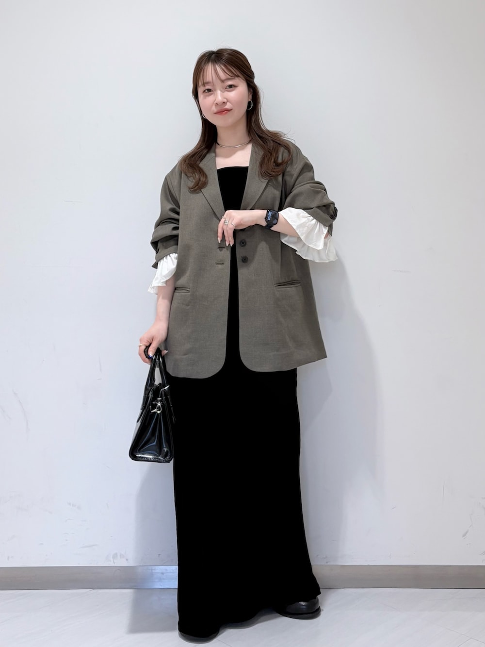 ブラック系のサンダル、グレー系のその他アウター、ブラック系のボストンバッグを着用したレディースの春コーディネートの2枚目の写真