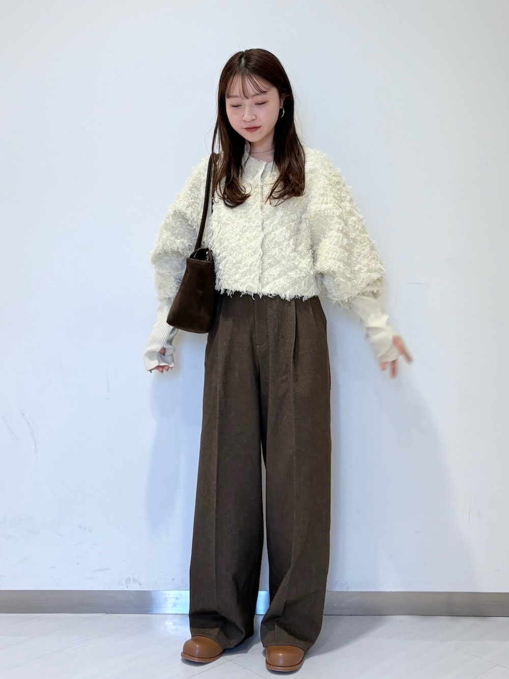 ホワイト系のカーディガン/ボレロ、ブラウン系のその他パンツ、ブラウン系のボストンバッグを着用したレディースの冬コーディネートの2枚目の写真