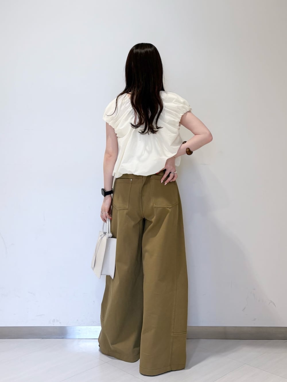 ホワイト系のシャツ/ブラウス、グリーン系のその他パンツ、ホワイト系のハンドバッグを着用したレディースの春コーディネートの3枚目の写真