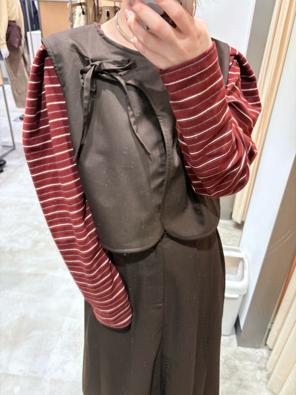 ブラウン系のワンピース、ブラック系のブーツ、レッド系のカーディガン/ボレロを着用したレディースの秋コーディネートの3枚目の写真